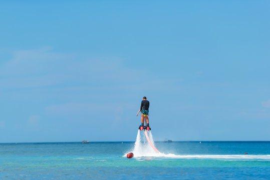 Water extreme sport. The guy is flying at the aquatic flyboard. Extreme rest on the sea. A lot of water pressure.