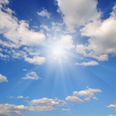 Naklejka na ściany i meble In the blue sky bright sun and light clouds.