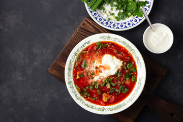 Traditional  ukrainian russian traditional beet red soup - borscht with sour cream on black stone background. Top view.