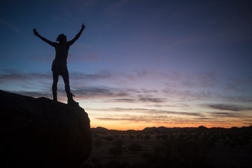Fototapeta na wymiar A tourist enjoying the sunset while camping in Namibia.