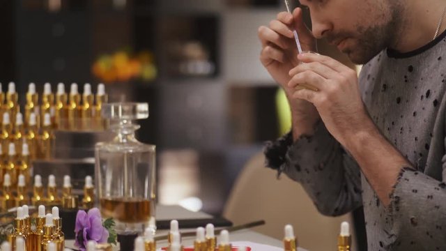 Portrait of young man blending scents for new perfume