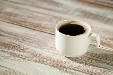 Cup of coffee with brown sugar on a wooden table.