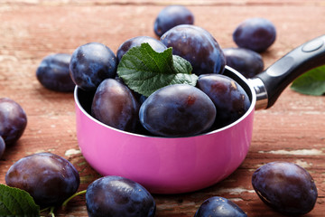 ripe plums in a saucepan on the table