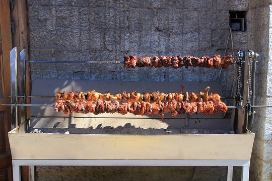 Large outdoor rotisserie with roast traditional Greek food of "kontosouvli" pieces of meat of chicken lamb and pork in village Monodentri  in Greece