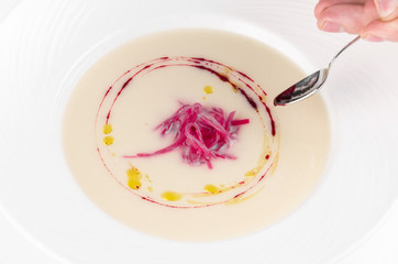 Preparation for serving of ream soup of cauliflower with beetroot and truffle oil