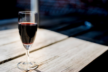 glass of red port, on wooden table, space for text