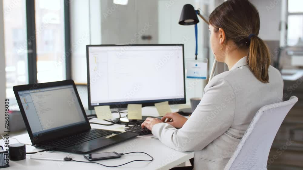 Poster business, programming and technology concept - female programmer with computer working at office and