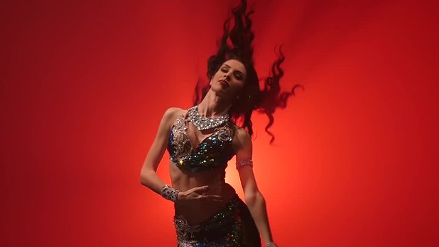 Traditional oriental belly dancer woman dancing . Red smoke background. Slow motion. Close up