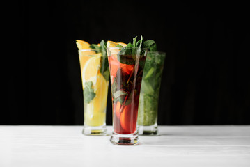 Close up photo selection of cocktails with mint, orange,lime on white and black background indoor. top view