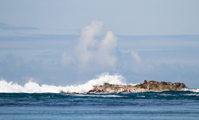 Fototapeta na wymiar Waves crash against the rocks at Port Wemyss, Islay, Scotland.