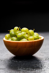 Image of gooseberry berries in wooden cup.