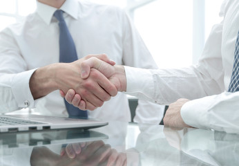close up.colleagues shaking hands over a Desk