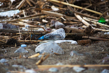 Spilled garbage on the beach.Empty used plastic bottle.