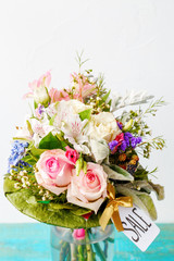Image of romantic bouquet of pink roses, lilies, green leaves