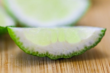 lime slices on wooden table, close up blurry background