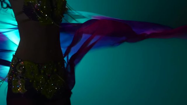 Arab dancer performs belly dance. Black background. Slow motion. Close up