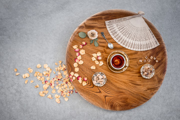 Vintage wooden table with tea and rose petals