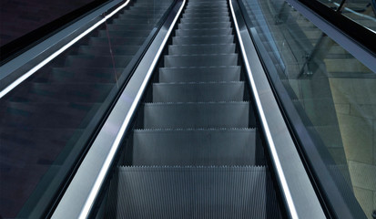 Looking down a metal escalator staircase 