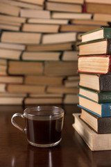Naklejka premium cup of coffee on the background of books