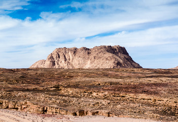 Fototapeta na wymiar high mountain in the desert against the blue sky and white clouds in Egypt Dahab South Sinai