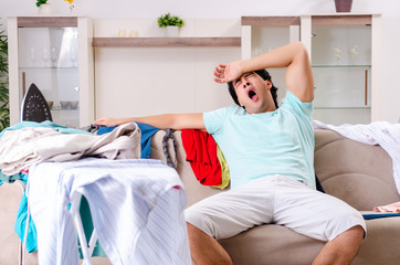 Young man husband ironing at home