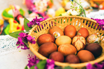 Easter painted eggs in the basket on table