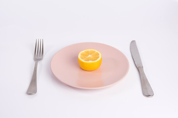 half a lemon on a plate isolated on white background