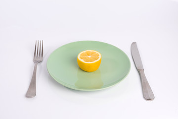 half a lemon on a plate isolated on white background