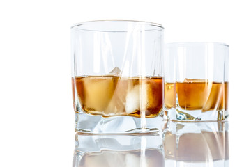Whiskey with ice close-up in a glass isolated on a white background