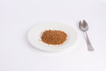 buckwheat groats on a plate isolated on white background