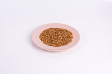 buckwheat groats on a plate isolated on white background