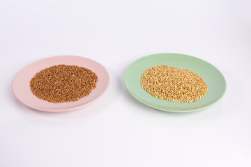  green and brown buckwheat  on a plate isolated on white background