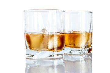 Whiskey with ice close-up in a glass isolated on a white background