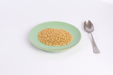 green buckwheat on a plate isolated on white background