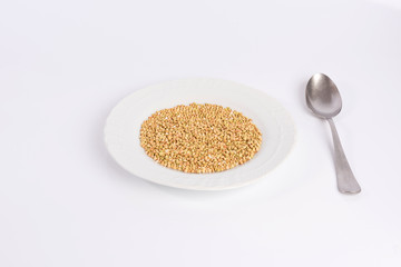 green buckwheat on a plate isolated on white background