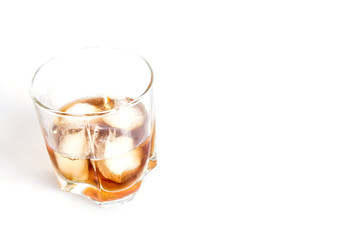 Whiskey with ice close-up in a glass isolated on a white background