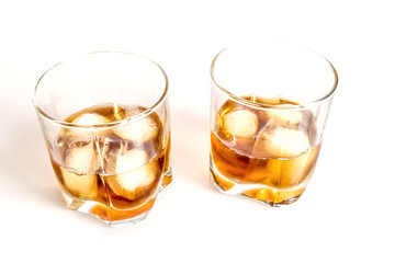 Whiskey with ice close-up in a glass isolated on a white background