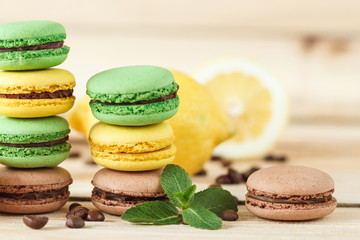 Green and yellow french macarons with kiwi, lemon and mint decorations