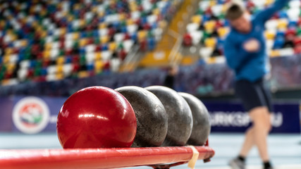 Rear view sportsman practising shot put against view of a stadium