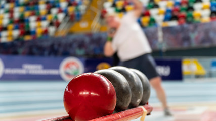 Rear view sportsman practising shot put against view of a stadium