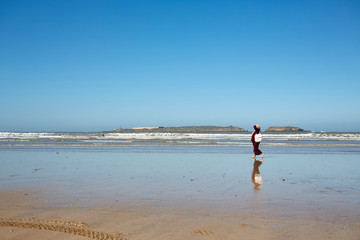 Junge Frau geht allein am Strand spazieren