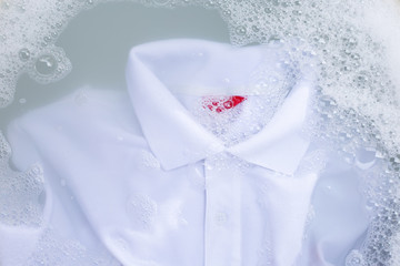 Soak a cloth before washing, white polo shirt. Top view
