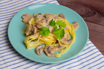 Pasta with creamy mushroom sauce on a blue plate