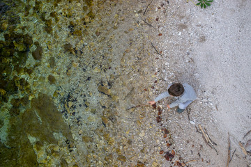 Toddler boy playing by the river