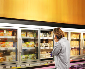 Man choosing frozen food from a supermarket freezer