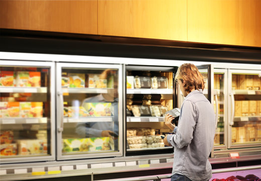 Man choosing frozen food from a supermarket freezer