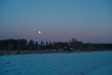 Winter evening landscape with moon