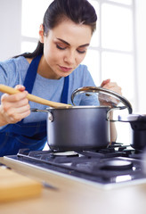 Cooking woman in kitchen with wooden spoon
