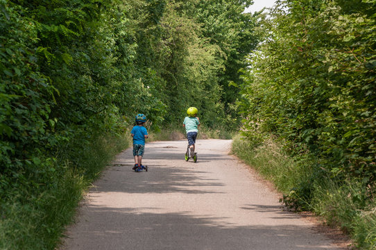 Kinder beim Rollerfahren mit Helm