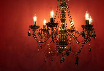 Luster as old fashion ceiling lamp decorated with metallic crystals and chains with overall golden...